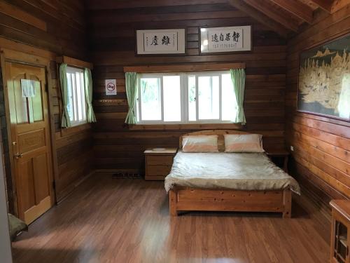 a bedroom with a bed in a wooden cabin at Jin Zu Cottage in Lugu