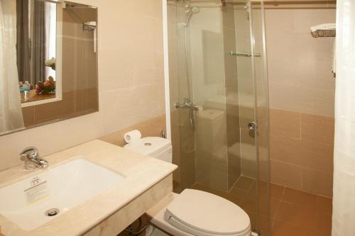 a bathroom with a shower and a toilet and a sink at Elegant Hotel in Pleiku