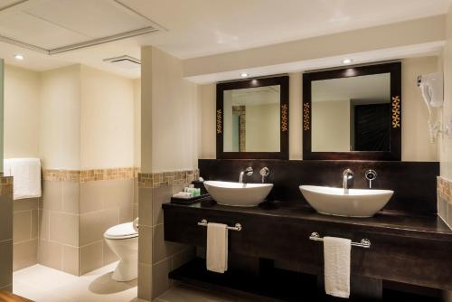 La salle de bains est pourvue de 2 lavabos, de toilettes et de miroirs. dans l'établissement The Warwick Fiji, à Korolevu