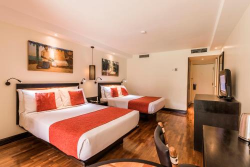 a hotel room with two beds and a desk at The Warwick Fiji in Korolevu