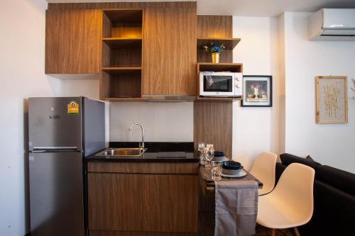 a small kitchen with a sink and a refrigerator at SimplyComfy Apartment by Patsamon in Pattaya South