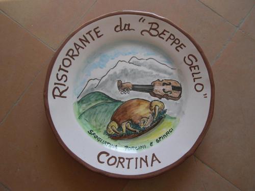 a sign on a wall with a picture of a bear at Hotel da Beppe Sello in Cortina dʼAmpezzo