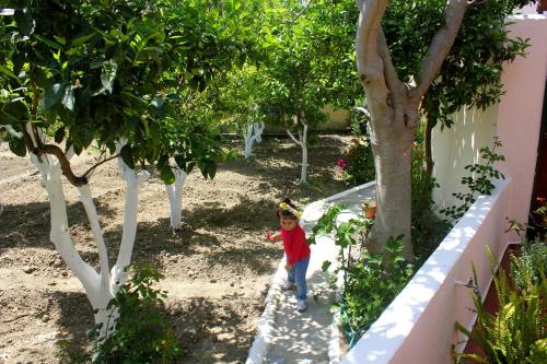 a young child walking down a path in a garden at Hariklia Rent Rooms in Zarós