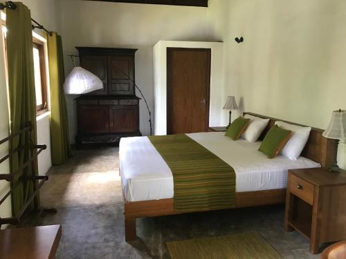 a bedroom with a large bed and a dresser in it at Villa by the Lake Bolgoda, Moratuwa-Colombo in Moratuwa