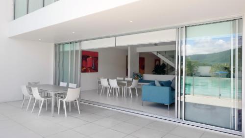 a living room with a blue couch and a table and chairs at Pool Resort Port Douglas in Port Douglas
