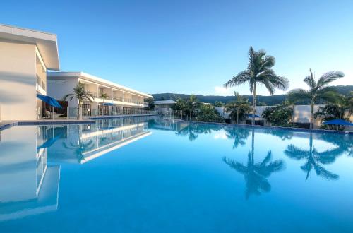 a swimming pool at a resort with palm trees at Pool Resort Port Douglas in Port Douglas