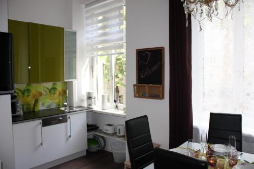 a kitchen with green cabinets and a table with chairs at govienna - City Center Apartments in Vienna