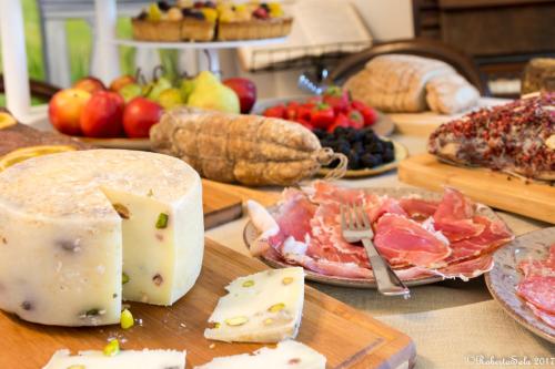 una mesa cubierta con queso, carne y fruta en Agriturismo Monaci Templari, en Seborga