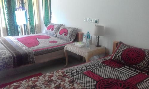 a bedroom with a bed and a chair and a table at Hamadhi guest in Haldummulla