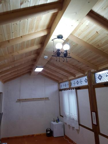 a room with wooden ceilings and a chandelier at The Hanok in Jeonju