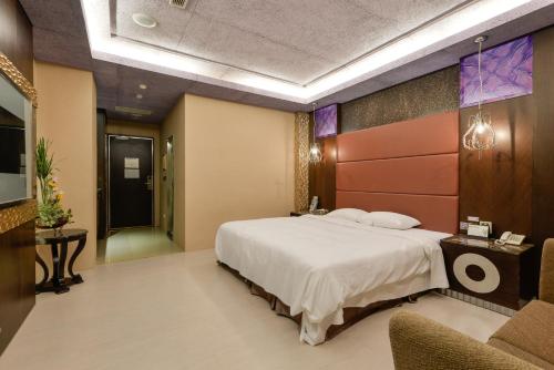 a bedroom with a large bed and a couch at R7 Hotel in Kaohsiung