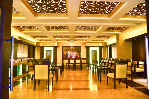 a restaurant with tables and chairs in a room at Hotel Sepal in Bathinda