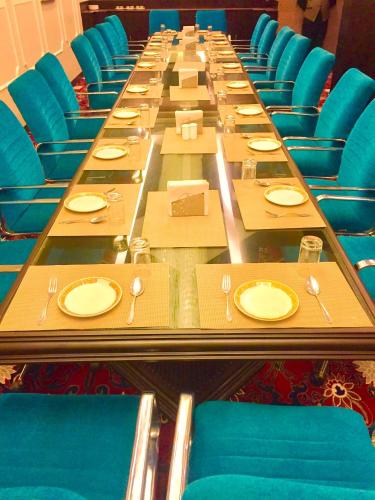 a long long table with plates and forks and napkins at Hotel Sepal in Bathinda