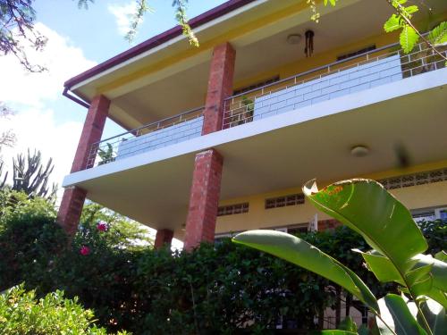 a building with columns and plants in front of it at Retreat Guesthouse Kitende in Entebbe