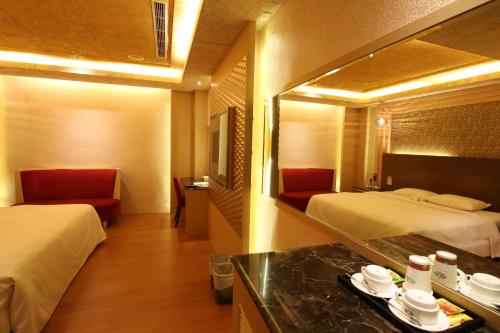 a hotel room with two beds and a mirror at R7 Hotel in Kaohsiung