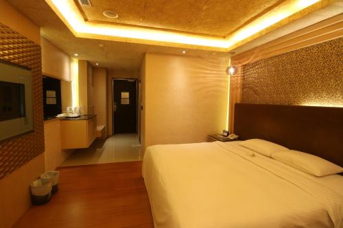 a hotel room with a bed and a hallway at R7 Hotel in Kaohsiung