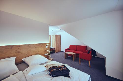 a bedroom with a bed and a red chair at Die Burg in Donaueschingen