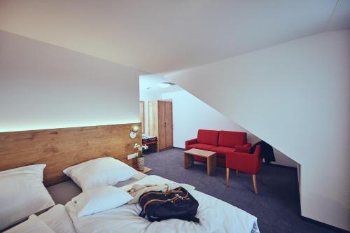 sypialnia z łóżkiem i czerwonym krzesłem w obiekcie Die Burg w mieście Donaueschingen