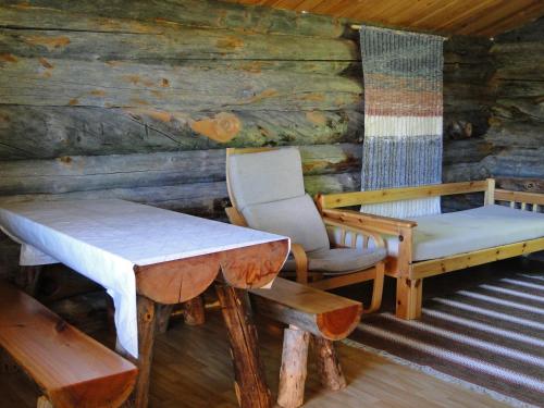 een kamer met een bed, een tafel en een stoel bij Tenon näköalamökit in Utsjoki