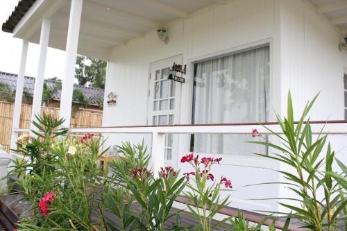 a white house with a window and pink flowers at Terrua Main Ten Villa Garden in Suan Phung