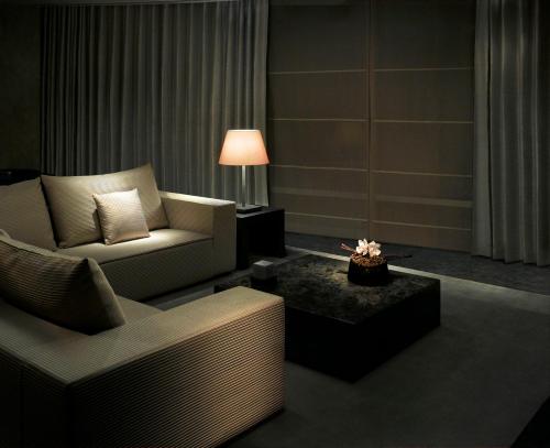Armani Hotel Dubai, Burj Khalifa في دبي: غرفة معيشة مع أريكة وكرسي وطاولة