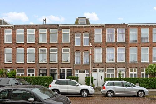 un grand bâtiment en briques avec des voitures garées dans un parking dans l'établissement Hotel Bor Scheveningen, à Scheveningen