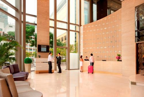 a group of people standing in a lobby with luggage at Dorsett Mongkok, Hong Kong in Hong Kong