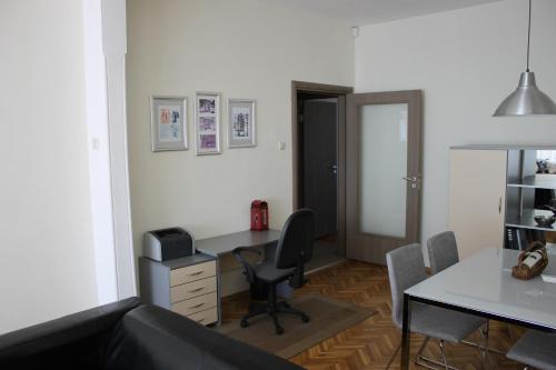 an office with a desk and a chair and a table at IMG Apartment in Sofia