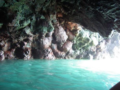 a cave with blue water in front of a cliff at Agriturismo La Collina Verde in Levanto