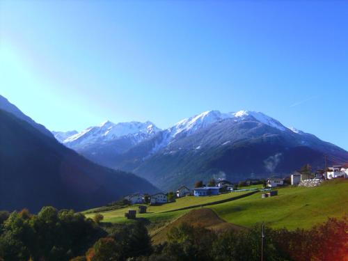 a village on a hill with mountains in the background at Neuner Charlotte Preise inclusive Sommercard in Wenns