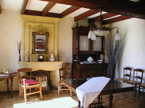 une salle à manger avec une table et des chaises et une cheminée dans l'établissement Galot La Chapelle, à Gardegan-et-Tourtirac