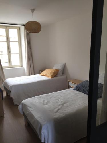 a bedroom with two beds and a window at La Houle in Cancale