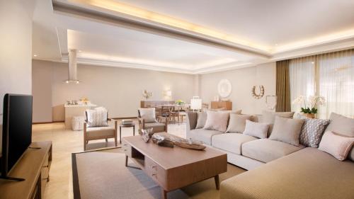 a living room with a couch and a table at The Sintesa Residence Jimbaran in Jimbaran
