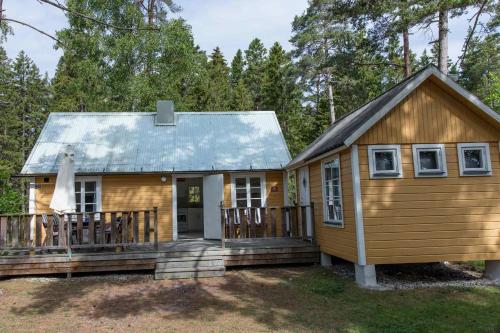 a tiny house with a porch and a deck at Ljugarn Semesterby in Ljugarn
