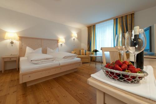 a hotel room with a bed and a bowl of strawberries at Hotel Krone Langenegg in Langenegg