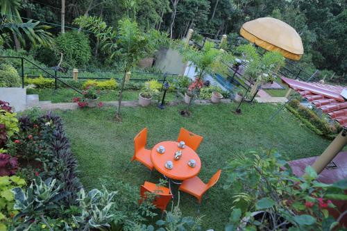 a garden with a table and chairs in the grass at The Springfields Kandy Previously Madara Residence Kandy in Kandy