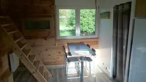 ein kleines Haus mit einem Tisch, Stühlen und einem Fenster in der Unterkunft La cabane de Denier in Denier