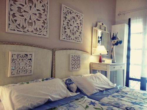ein Schlafzimmer mit einem Bett und einige Bilder an der Wand in der Unterkunft Patio Del Limonero in Córdoba