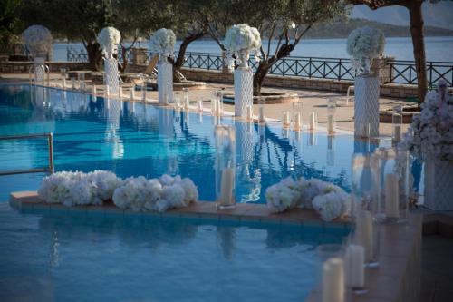 a row of white columns and candles in a pool at Europa Beach Hotel in Galaxidhion
