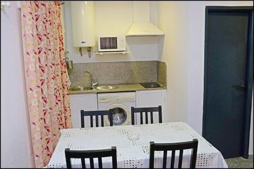 eine Küche mit einem Tisch und einem Hund am Tisch in der Unterkunft Apartamento Plaza España in Conil de la Frontera