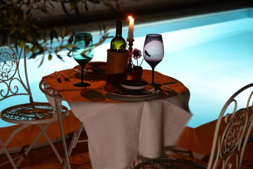 a table with a candle and wine glasses on it at B&B Rita and Family in Loceri