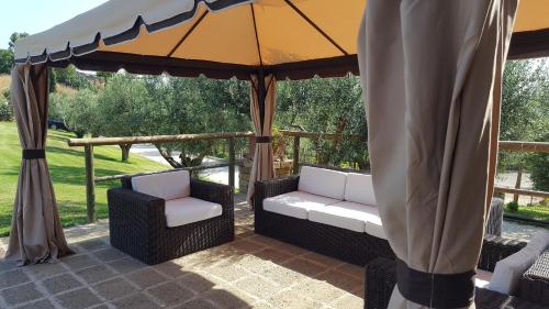 a patio with two chairs and an umbrella at Aquilamaior in Tragliata