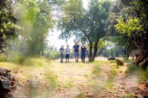 a group of people walking down a dirt path at Boubou Bed and Breakfast in Rustenburg