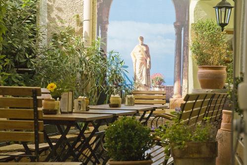 a statue of a man standing in a garden with a table at Restaurant Dicker Mann Hotel zum Blauen Krebs in Regensburg