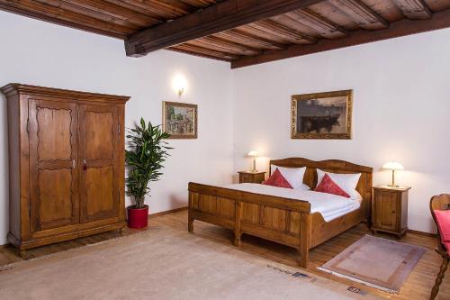 a bedroom with a wooden bed with red pillows at Restaurant Dicker Mann Hotel zum Blauen Krebs in Regensburg