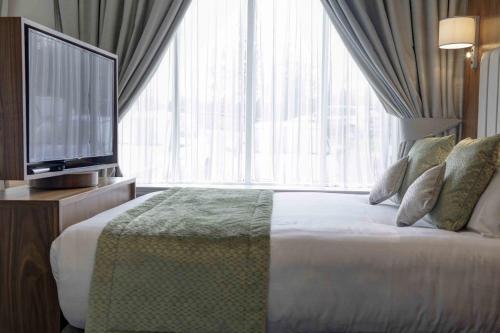 a hotel room with a bed and a television at The Croft Hotel in Darlington