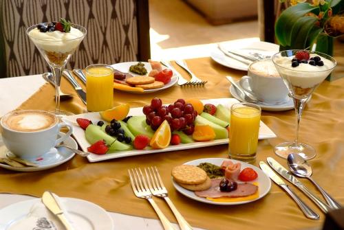 a table with plates of food and glasses of coffee at Royal Palm Hotel in Durban