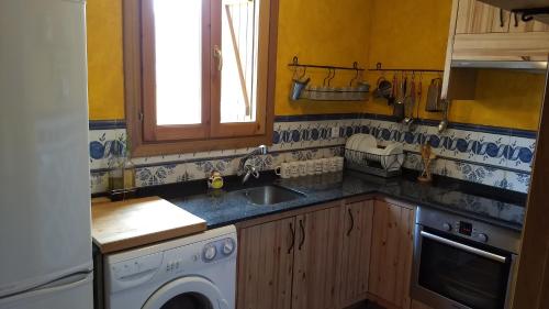 a kitchen with a sink and a washing machine at Casa Montenegro in Las Colladas