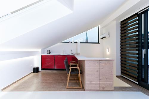 a kitchen with red cabinets and a sink and a window at BA Apartments in Sarajevo