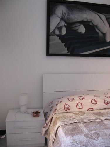 a bedroom with a bed and a picture on the wall at Stanza d'artista in Genova